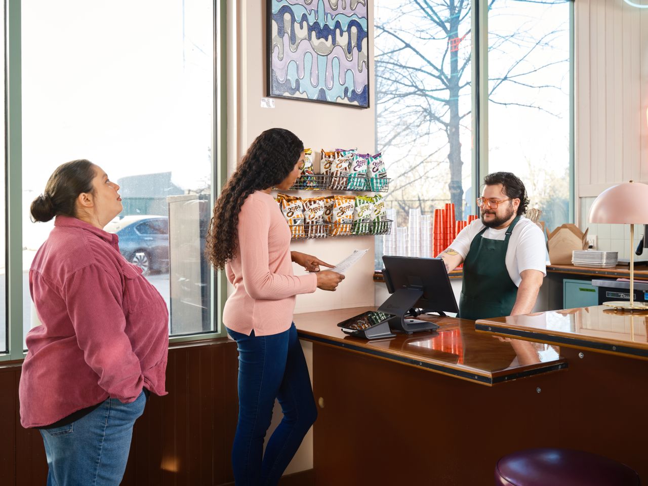 Mastering the First Impression: Your intriguing post title goes here Two customers interacting with staff at a restaurant point of sale counter.