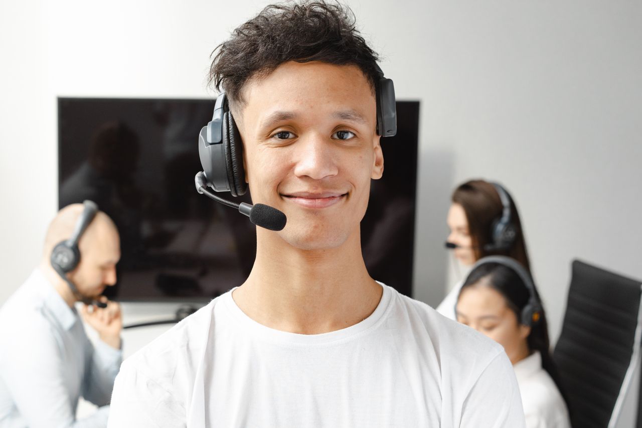 Crafting Captivating Headlines: Your awesome post title goes here Professional call center agent wearing a headset, smiling confidently in a modern office setting.